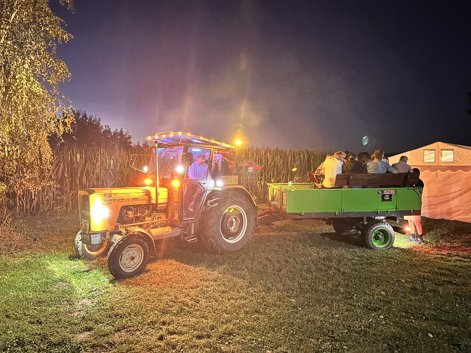 Festyn Jama 2026: traktor z przyczepą wśród pól kukurydzy nocą